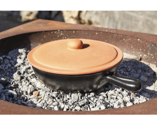 Pot de cuisson en céramique avec couvercle sur charbon de bois