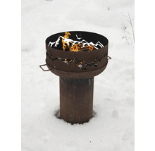 Brasero en métal avec motif de montagne et bois qui brûle dans la neige