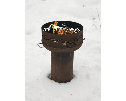 Brasero en métal avec motif de montagne et bois qui brûle dans la neige