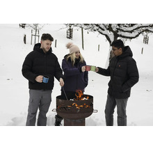 Trois personnes se tiennent dans la neige autour d'un foyer avec des tasses à la main.