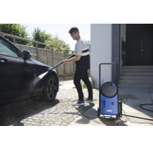 Homme nettoie une voiture avec un nettoyeur haute pression