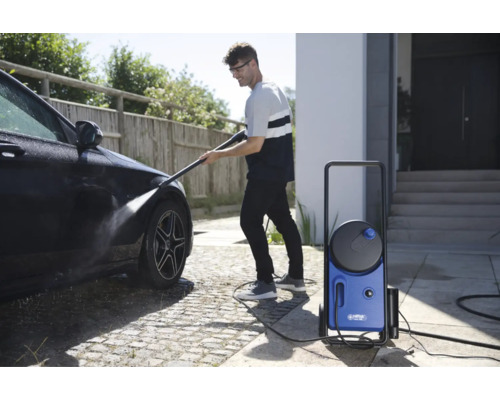 Homme nettoie une voiture avec un nettoyeur haute pression