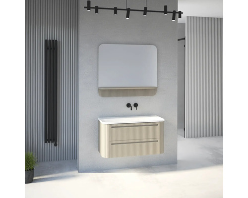 Modernes Badezimmer Set mit beigem Waschbeckenunterschrank in Rillenoptik, weißem Waschtisch, Spiegel mit Ablage und schwarzen Armaturen.