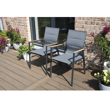 Zwei graue Gartenstühle mit Armlehnen aus Holz auf einer Terrasse.