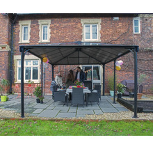 Pavillon de jardin avec famille et table à manger à l'extérieur devant un bâtiment en briques