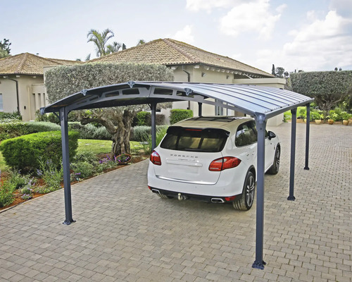 Voiture sous un abri de voiture sur une allée pavée