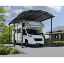 Wohnmobil unter einem Metallcarport auf einem Grundstück.