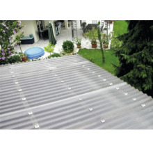 Tôle ondulée transparente sur un toit avec jardin en arrière-plan.