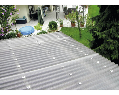 Tôle ondulée transparente sur un toit avec jardin en arrière-plan.