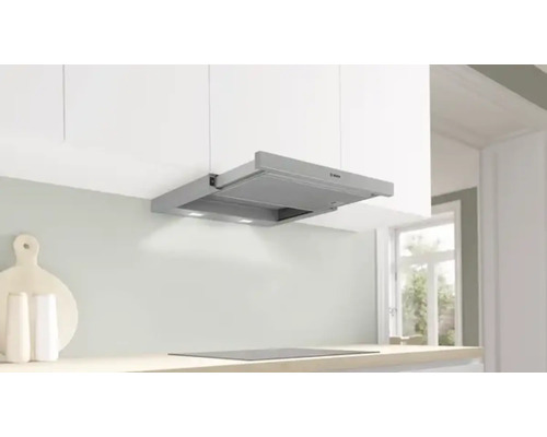 Hotte aspirante argentée dans une cuisine claire avec plaque de cuisson et logo Bosch.