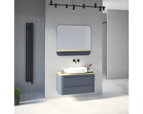 Salle de bains moderne avec meuble sous-vasque bleu, plan en bois, vasque à poser blanche, miroir et robinetterie murale noire.