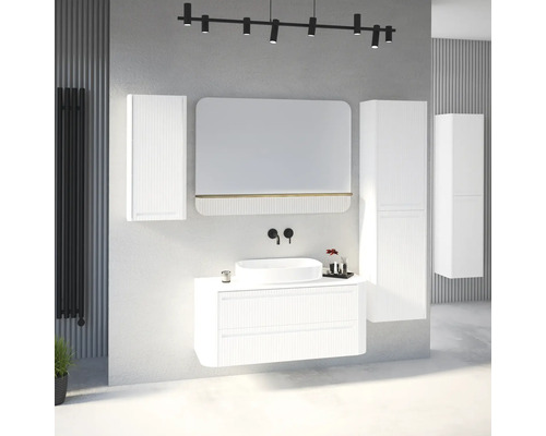 Ensemble de meubles de salle de bain blanc moderne avec façades rainurées, vasque à poser, miroir et colonnes dans une pièce lumineuse et organisée.
