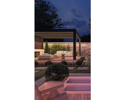 Stimmungsvolle Gartenszene mit Pergola, Loungemöbeln und stimmungsvoller Beleuchtung