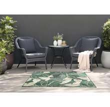 Scène de jardin avec deux fauteuils en rotin, une petite table et un tapis vert à motif de feuilles