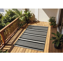 Terrasse avec un tapis rayé, un plancher en bois et des plantes