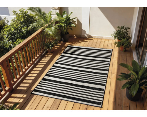 Terrasse avec un tapis rayé, un plancher en bois et des plantes