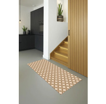 Innenaufnahme eines modernen Wohnraums mit einem gemusterten Teppich, einer schwarzen Küchenzeile und einer Holztreppe.