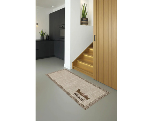 Szene eines Innenraums mit einem Teppich mit Dackelmotiv vor einer Treppe und einer Küche.