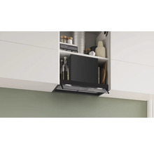 Dunstabzugshaube in einer modernen Küche mit weißen Schränken und verschiedenen Kochutensilien.