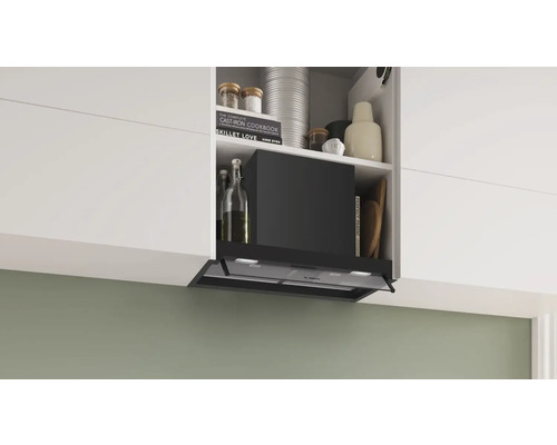 Dunstabzugshaube in einer modernen Küche mit weißen Schränken und verschiedenen Kochutensilien.