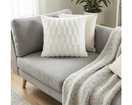 Graues Sofa mit Kissen und Strickdecke