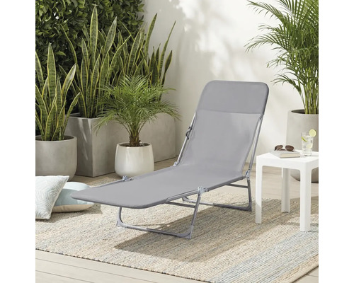 Chaise longue grise avec table d'appoint à l'extérieur