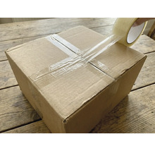 Un carton est fermé avec du ruban adhésif transparent.