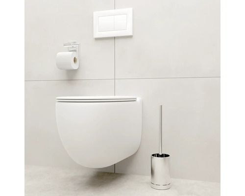 Wandhängendes WC mit Betätigungsplatte, Toilettenpapierhalter und Toilettenbürste in einem hellen Badezimmer.