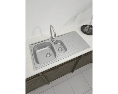 Spüle aus Edelstahl mit Abtropffläche und Wasserhahn auf einer Arbeitsplatte