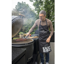 Un homme mesure la température de la viande sur un gril Outdoorchef avec un thermomètre