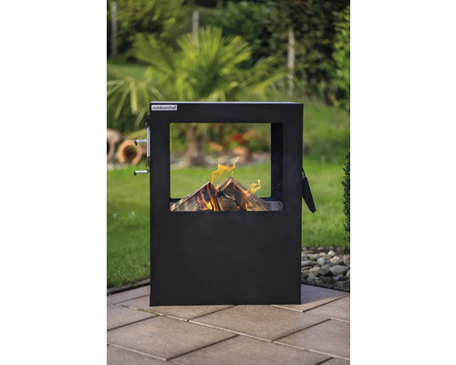 Outdoorchef Feuerstelle mit brennendem Holz im Garten