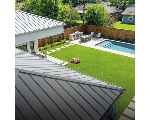 Vue d'un jardin avec robot tondeuse, espace barbecue, table à manger et piscine.