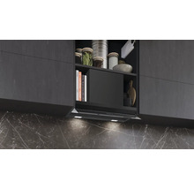 Küchenszene mit Dunstabzugshaube unter Hängeschrank mit Kochbüchern und Küchenutensilien