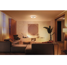 Salon avec canapé modulable, fauteuil et plafonnier rond