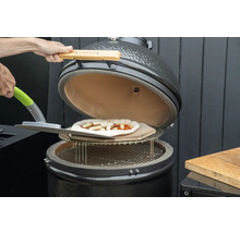 Barbecue en céramique avec pizza sur pierre à pizza et pelle à pizza