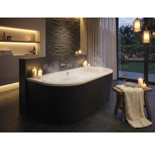 Elegantes Badezimmer mit freistehender Badewanne, Kerzen und indirekter Beleuchtung für eine entspannende Atmosphäre