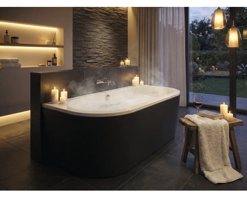 Elegantes Badezimmer mit freistehender Badewanne, Kerzen und indirekter Beleuchtung für eine entspannende Atmosphäre