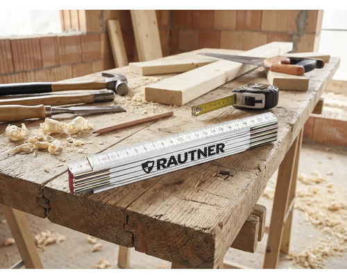 Établi avec marteau, ciseau à bois, mètre pliant de la marque Rautner, crayon, laine de bois, scie et mètre ruban