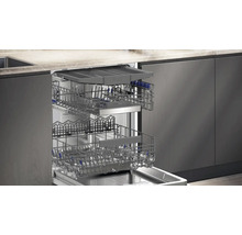 Lave-vaisselle ouvert avec deux paniers à vaisselle dans une cuisine intégrée