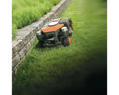 Robot tondeuse Landroid sur pelouse à côté d'un mur