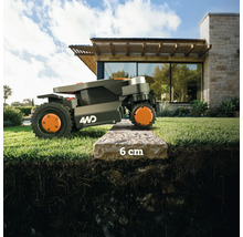 Une tondeuse robot franchit une bordure de trottoir de 6 centimètres.