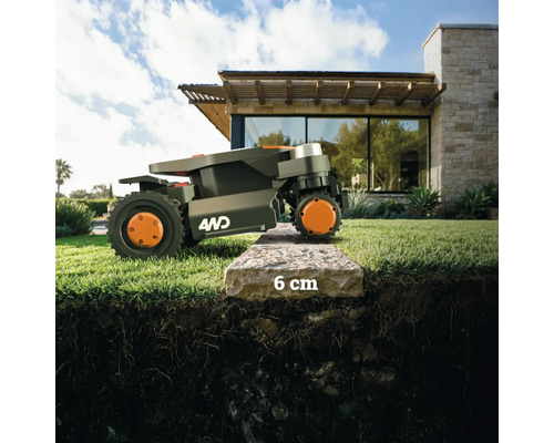 Une tondeuse robot franchit une bordure de trottoir de 6 centimètres.