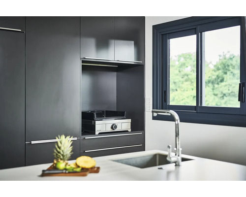 Cuisine moderne avec armoires, fenêtre et gril de table