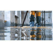 Personne utilisant un aspirateur eau et poussière pour éliminer l'eau