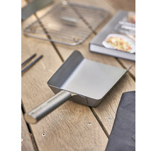 Grillschaufel aus Metall auf Holztisch