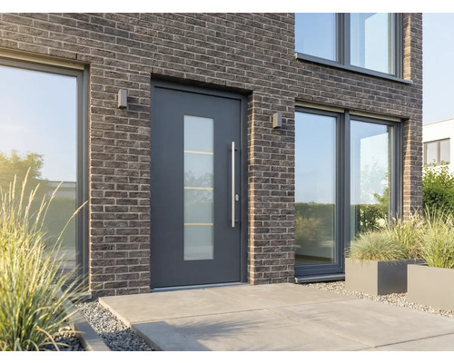 Maison moderne avec porte d'entrée avec insert en verre, façade en brique et grandes fenêtres