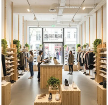 Vue intérieure d'un magasin de vêtements avec des clients et une sélection de chaussures et de vêtements
