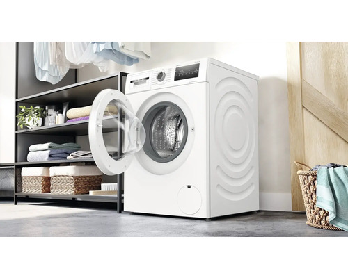 Weisse Waschmaschine mit geöffneter Tür in einem Badezimmer