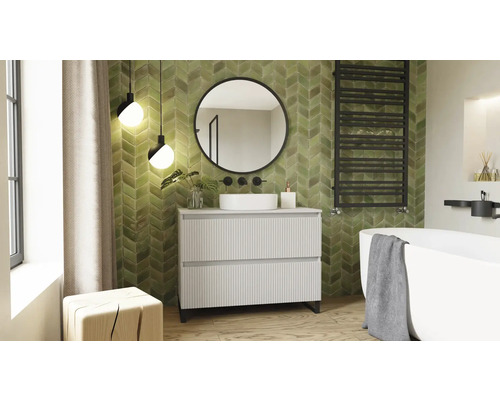 Salle de bains avec meuble-lavabo, miroir, baignoire et radiateur devant un mur carrelé.