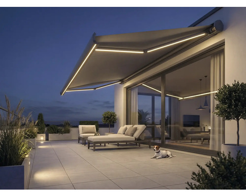 Terrasse avec store, mobilier de jardin et éclairage en soirée